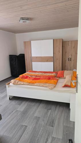 a large white bed in a room with a wooden floor at Hüller Ferienwohnung in Gräfenberg