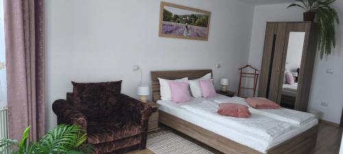 a bedroom with a bed with pink pillows and a mirror at Casa Maria in Avrig