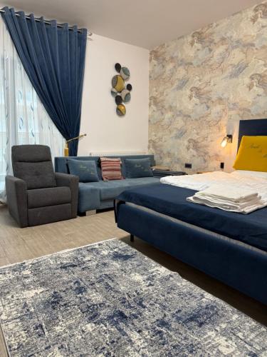 a bedroom with a bed and a couch and a chair at Studio Matias 2 Casa Del Mar in Mamaia