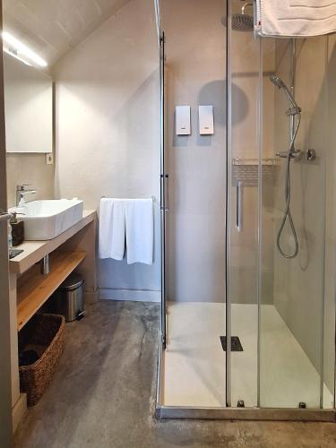 a bathroom with a glass shower and a sink at Hotel Casa Calella in Calella de Palafrugell