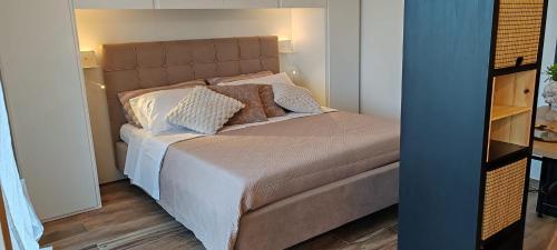 a bedroom with a bed with white sheets and pillows at Mini loft moderno di fronte Zoomarine in Torvaianica