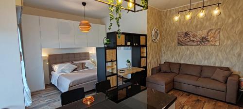a living room with a bed and a couch at Mini loft moderno di fronte Zoomarine in Torvaianica