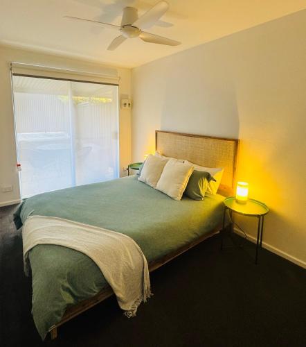 a bedroom with a bed with a lamp on a table at Sea Breeze with City Ease in Port Lincoln
