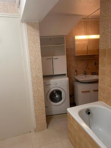 a small bathroom with a washing machine and a sink at À 100m de l ocean in Longeville-sur-Mer