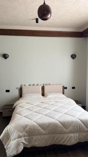 a bedroom with a large white bed with a ceiling at Jessica's House in Luxor