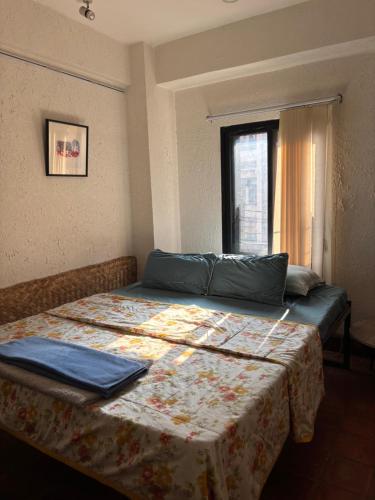 a bedroom with a bed with a laptop on it at Davu Gallery Cafe in Kathmandu