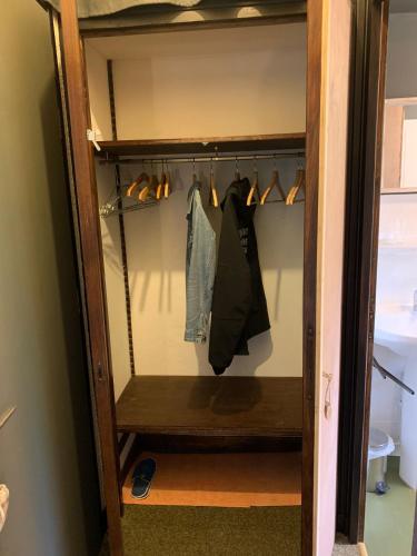 a walk in closet with hangers and shoes at Bouquetin studio cosy in Notre-Dame-de-Bellecombe