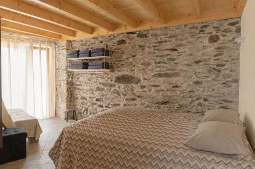 a bedroom with a stone wall and a bed at Casa Saudade Vila Real North in Vila Real