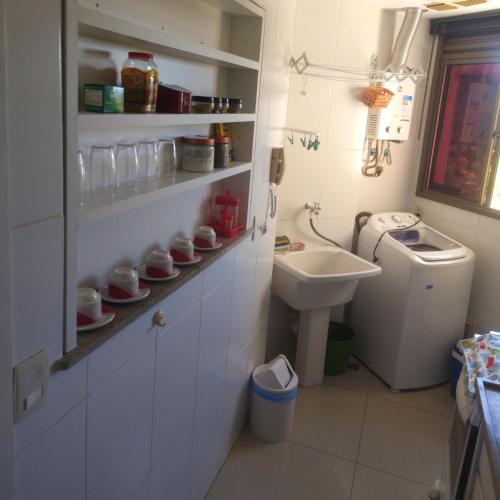 a small bathroom with a sink and a toilet at Loft no Refúgio do Sahy in Mangaratiba