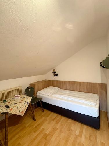 a small room with a bed and a table at Pension Schwartzwirt in Neusiedl am Steinfelde
