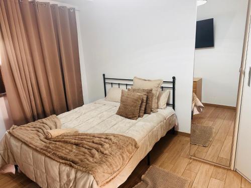 a bedroom with a bed with a blanket and a mirror at Casa Paz in Alcabideche