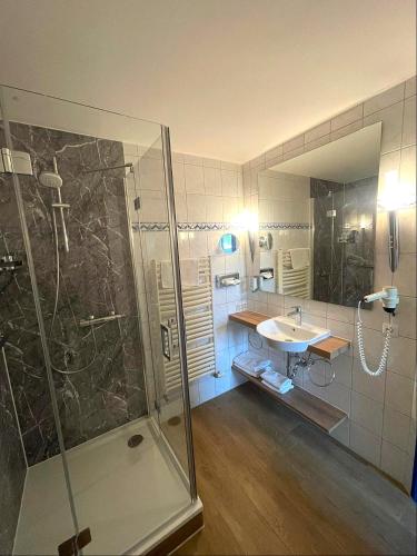 a bathroom with a shower and a sink at Sporthotel Middelpunkt in Aurich