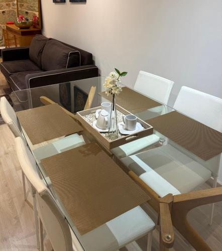 a dining room table and chairs with flowers on it at Vida Entre Balcones in Combarro