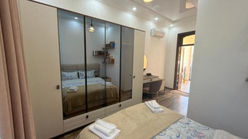 a bedroom with a large glass cabinet with a bed at Green House Marina in Batumi