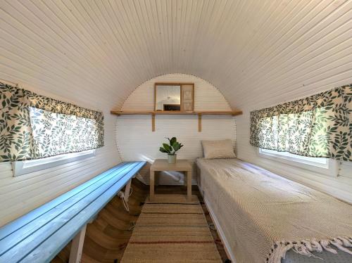 zwei Betten in einem kleinen Zimmer mit Fenstern in der Unterkunft Whispering Woods Cabin in Porvoo