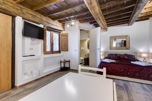 um quarto com uma cama e uma televisão na parede em Pellegrino Campo de' Fiori Suite em Roma