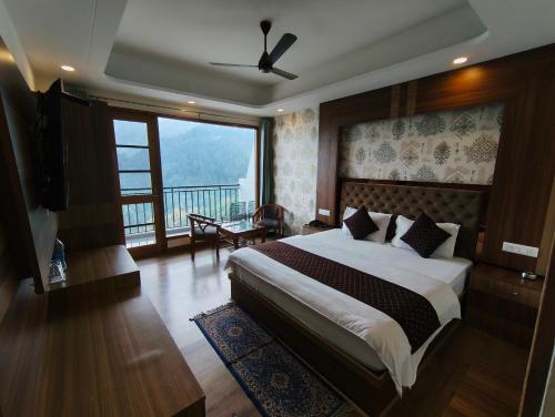 a bedroom with a bed and a large window at Hotel Summer Hill in Chail