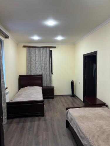 a bedroom with two beds and a window at Happy Holidays in Yerevan