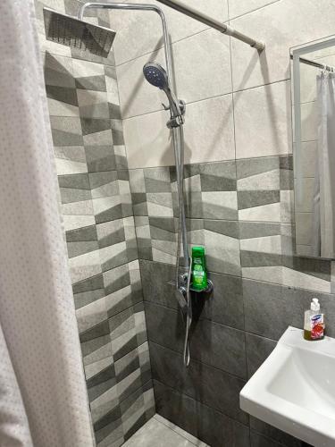 a bathroom with a shower with a green bottle in it at Happy Holidays in Yerevan