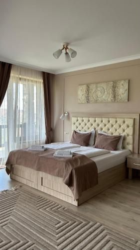 a bedroom with a large bed with a large window at Вершина in Pilipets