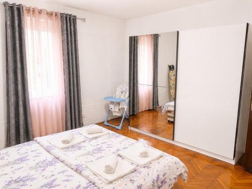 a bedroom with a bed with a mirror and a table at Apartman Stefan in Kotor