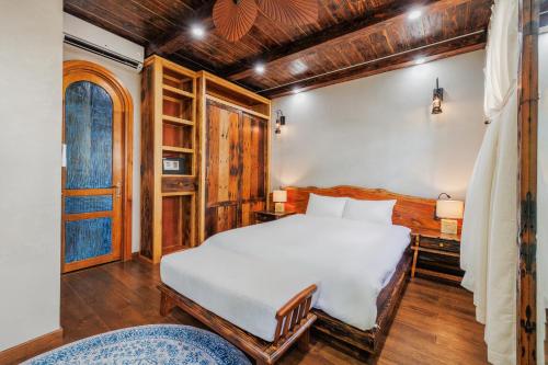 a bedroom with a white bed and a wooden ceiling at Little Sun Homestay - Free Buggy Tour check-in Sunset Town in Phú Quốc
