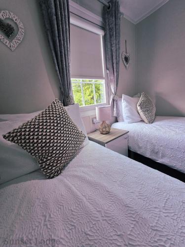 a bedroom with two beds and a window at Sunset lodge 32 in West Thirston