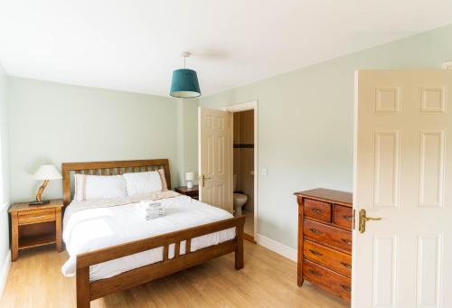 a bedroom with a bed and a dresser and a door at Riverview House - Cahersiveen in Cahersiveen