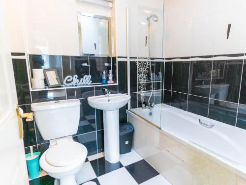 a bathroom with a toilet and a sink and a bath tub at Riverview House - Cahersiveen in Cahersiveen