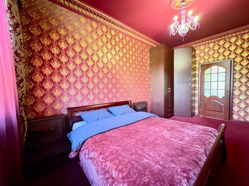 a bedroom with a large bed with a pink blanket at Aladdin apartment in Kharkiv