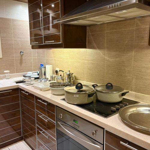 a kitchen with two pots on top of a stove at Mandarin Alshamal Hotel Apartments in Riyadh