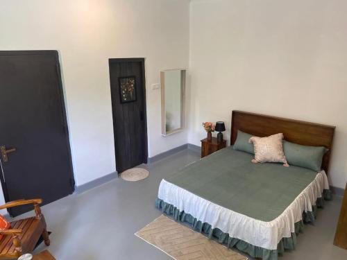a bedroom with a bed with a green comforter at Melani Villa in Kandy