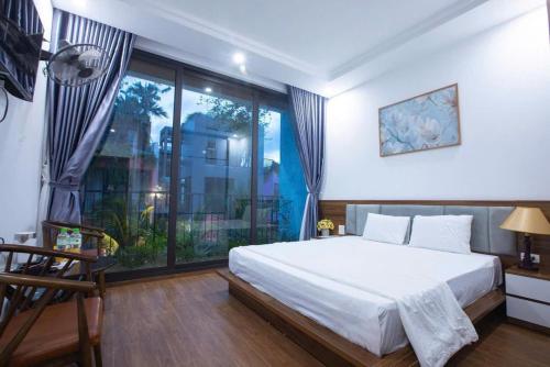 a bedroom with a bed and a large window at Villa Flamingo C607 in Thanh Hóa