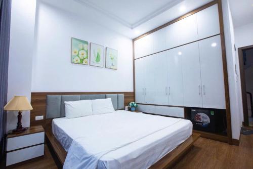 a bedroom with a large white bed and a tv at Villa Flamingo C607 in Thanh Hóa