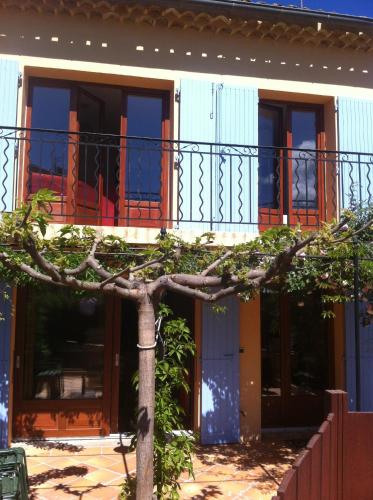 a building with a tree in front of it at Maison les Salles-sur-Verdon in Les Salles-sur-Verdon