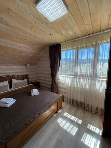 a bedroom with a bed and a large window at Beauty House in Mykulychyn