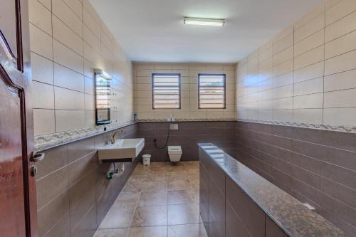 a bathroom with a sink and a toilet at Solana Pearl Beach Private Villa in Tiwi