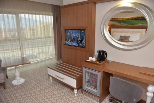 a living room with a fireplace and a mirror at Tuna Otel Rezi̇dans in Gülağzı