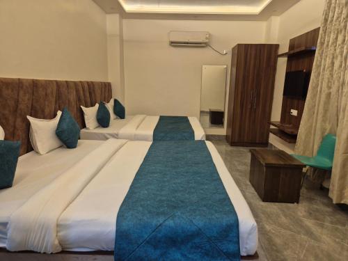 a hotel room with two beds and a chair at Hotel VR Plaza in Etah