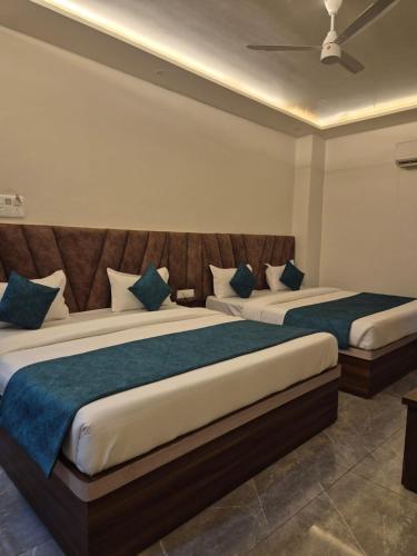 a bedroom with two beds with blue pillows at Hotel VR Plaza in Etah