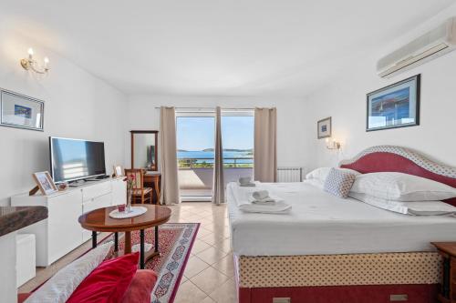 a living room with a bed and a television at Villa Baron - Adriatic Sea View in Šibenik