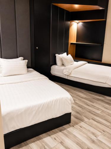 two beds in a room with black walls and wooden floors at الفرسان للشقق المخدومه in Al Kharj
