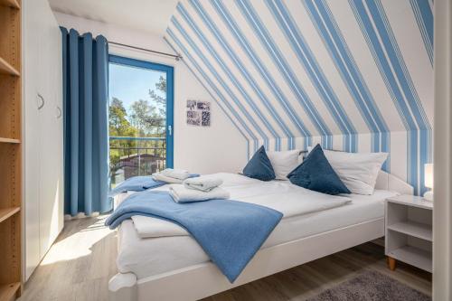 a bedroom with a bed with blue and white pillows at Meeresrauschen 1 in Groß Kirr