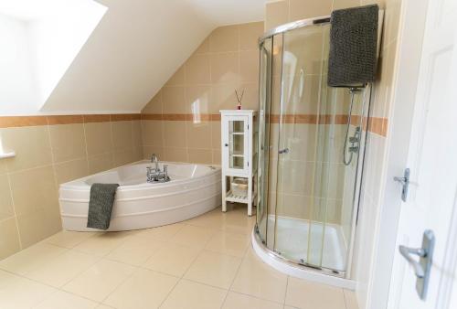 a bathroom with a bath tub and a shower at Winoma Lodge - Waterville in Waterville