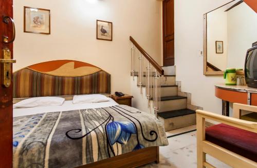 a bedroom with a bed and a staircase at Hotel Sunshine - Karol Bagh Budget Stay at New Delhi in New Delhi