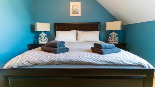 a blue bedroom with a bed with towels on it at Winoma Lodge - Waterville in Waterville