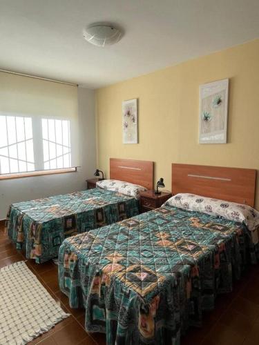 a hotel room with two beds and two windows at CHALET EN PLAYA ROBAYERA in Mogro
