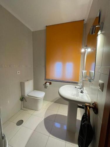 a bathroom with a white toilet and a sink at CHALET EN PLAYA ROBAYERA in Mogro
