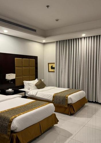 a hotel room with two beds and a window at شقق البيوتات المميزة للشقق المخدومة in Jeddah