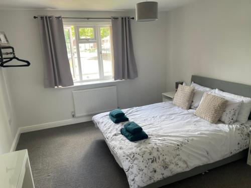 a bedroom with a bed with two blue towels on it at Modern spacious private detached house in Beeston